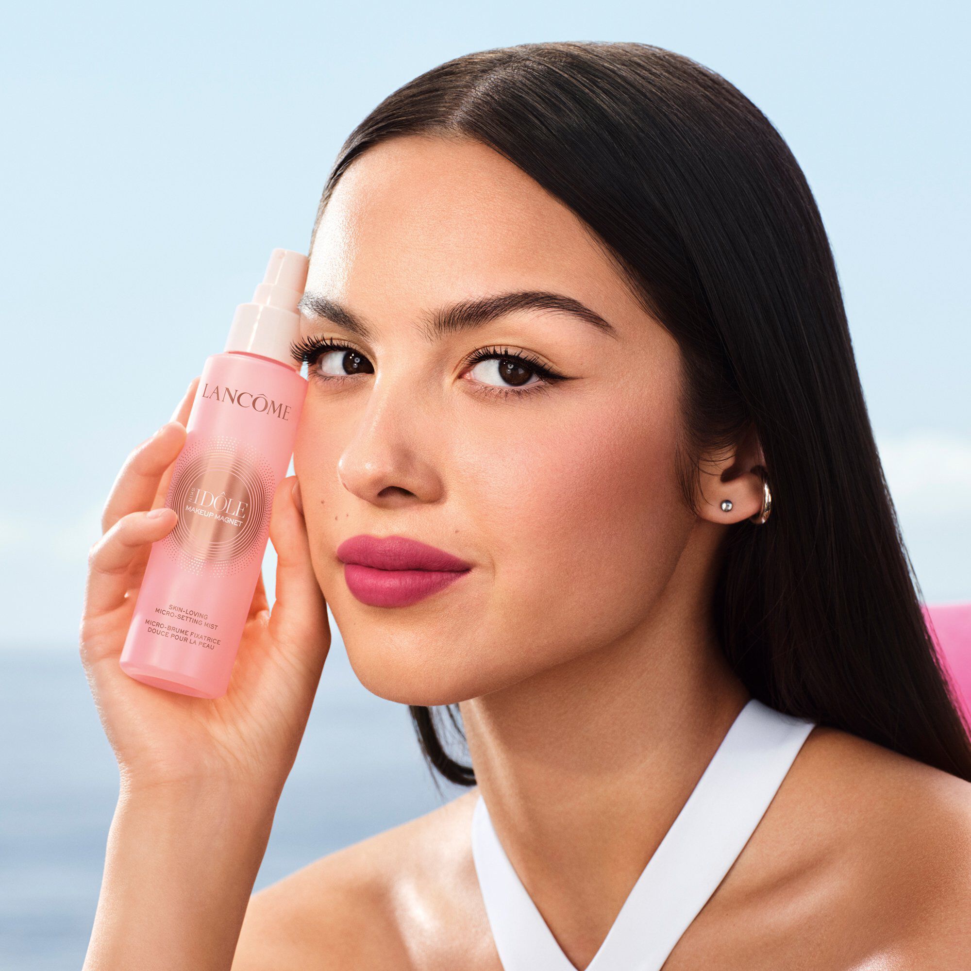 Pembe Lancome sabitleyici mist şişesini tutan Olivia Rodrigo.